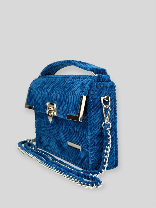 Amara Winter Blue is a luxury handmade designer bag by CATTLEYA.Y, defined by its deep blue tone and refined chevron texture. The structured silhouette creates a polished presence suitable for both elevated everyday wear and evening styling.
Amara Winter Blue structured blue handbag side view