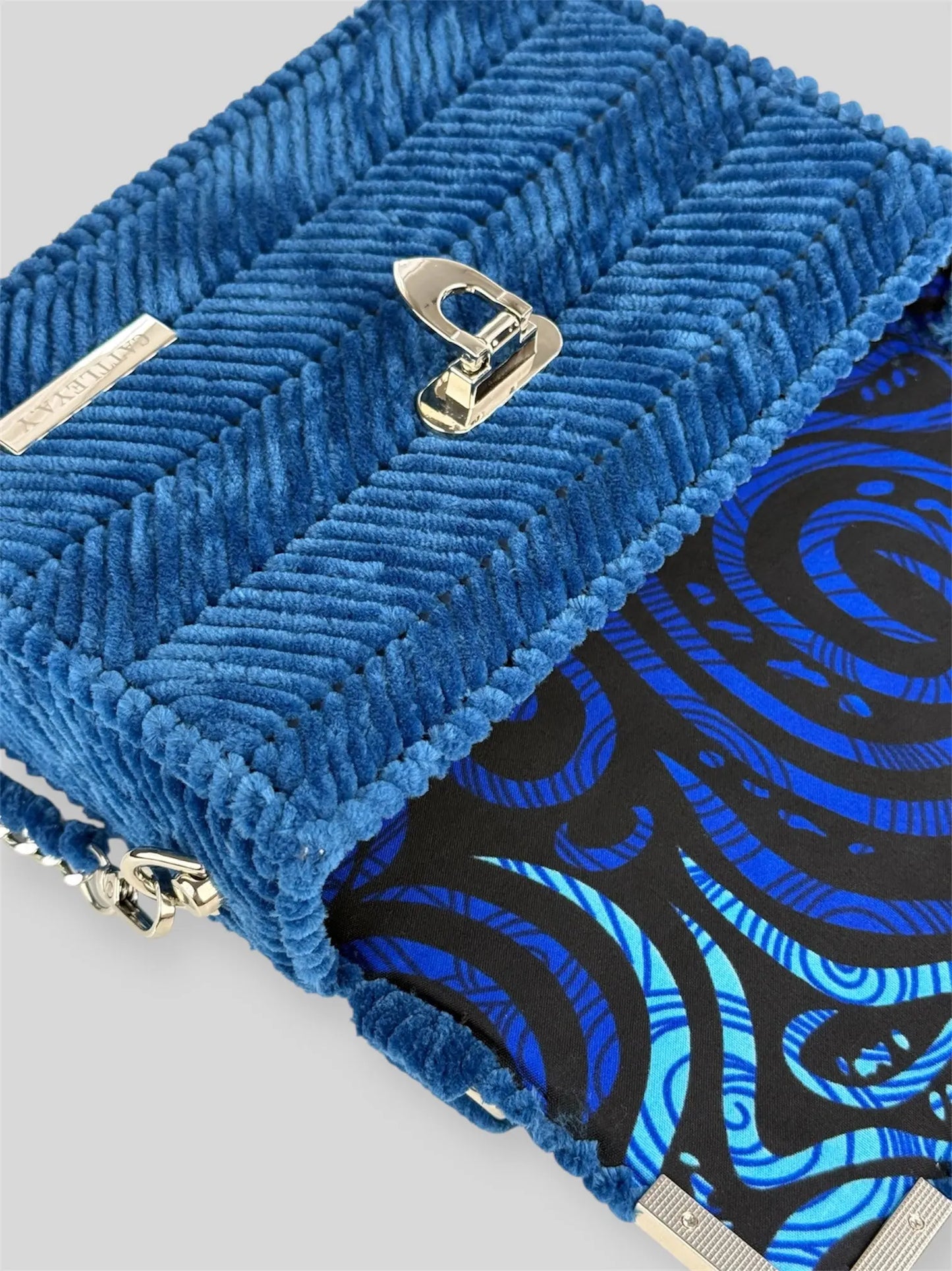 Amara Winter Blue is a luxury handmade designer bag by CATTLEYA.Y, defined by its deep blue tone and refined chevron texture. The structured silhouette creates a polished presence suitable for both elevated everyday wear and evening styling.
Patterned interior lining inside Amara Winter Blue handbag