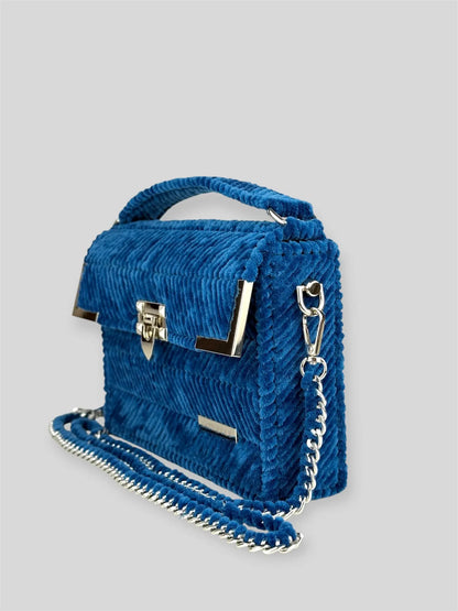Amara Winter Blue is a luxury handmade designer bag by CATTLEYA.Y, defined by its deep blue tone and refined chevron texture. The structured silhouette creates a polished presence suitable for both elevated everyday wear and evening styling.
Amara Winter Blue structured blue handbag side view
