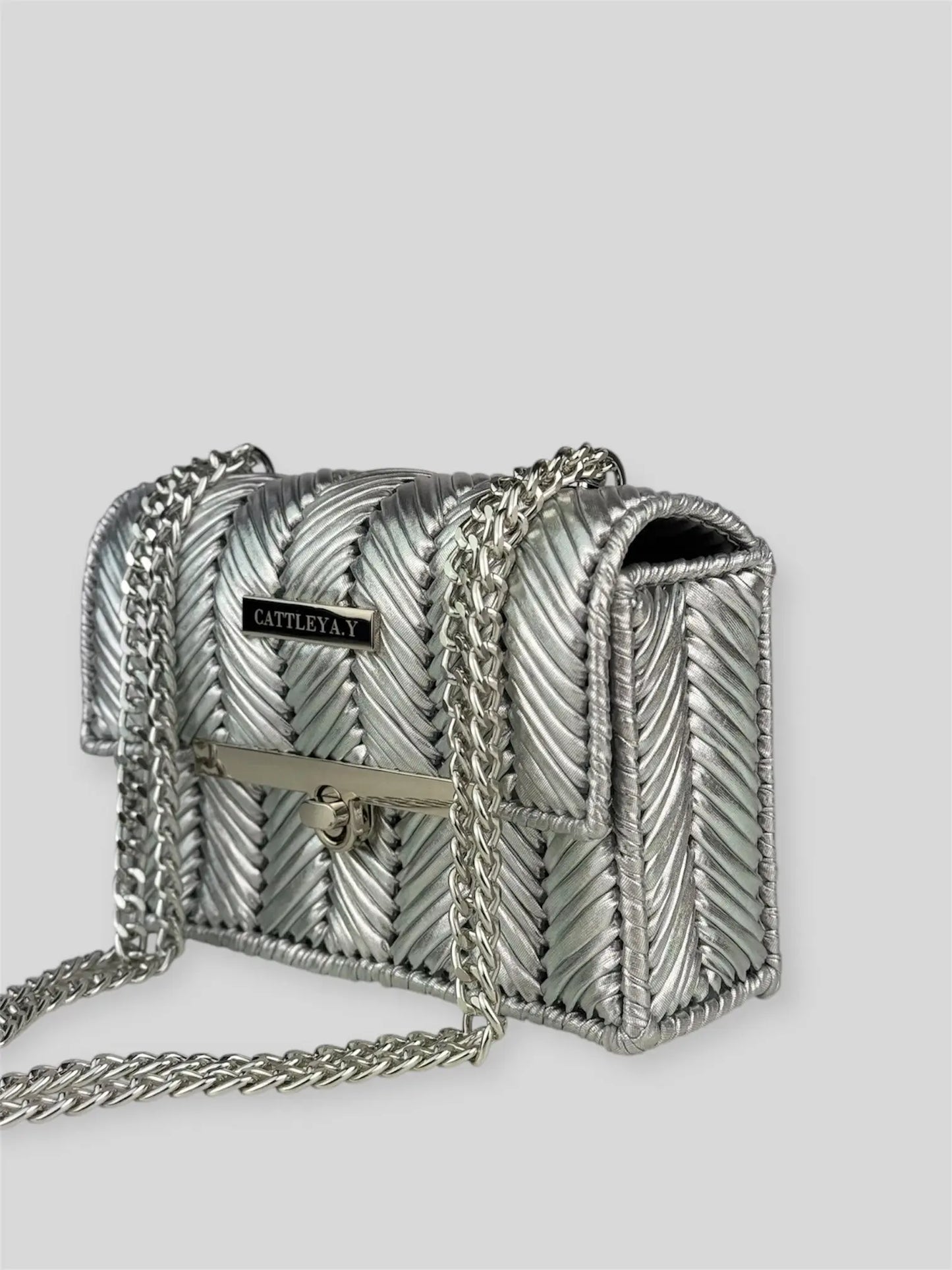 Brilliant Silver is a luxury handmade mini designer bag by CATTLEYA.Y, defined by its luminous metallic finish and refined chevron texture. The cool silver tone reflects light effortlessly, creating a striking yet sophisticated presence.
Brilliant Silver silver textured mini handbag with chain strap