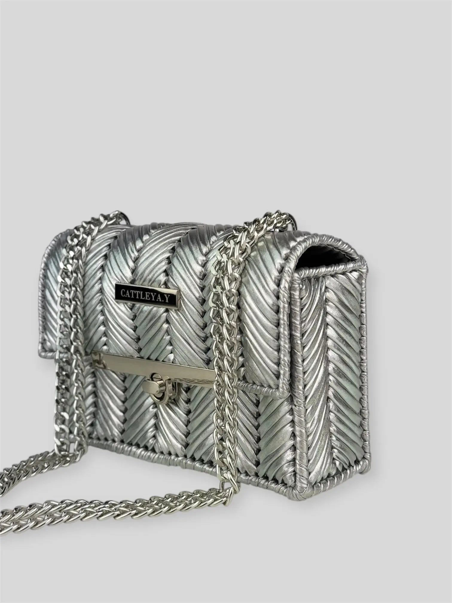 Brilliant Silver is a luxury handmade mini designer bag by CATTLEYA.Y, defined by its luminous metallic finish and refined chevron texture. The cool silver tone reflects light effortlessly, creating a striking yet sophisticated presence.
Brilliant Silver silver textured mini handbag with chain strap