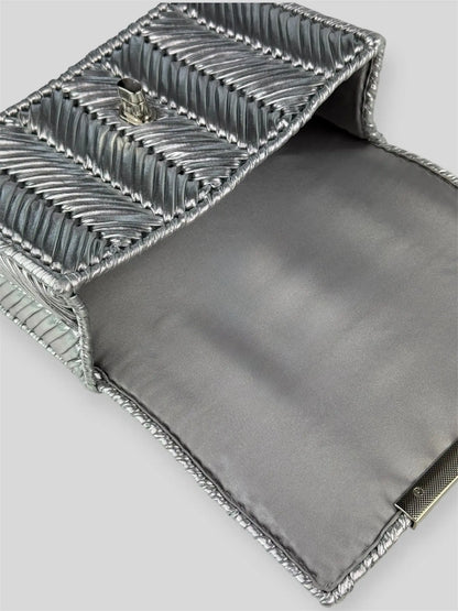 Brilliant Silver is a luxury handmade mini designer bag by CATTLEYA.Y, defined by its luminous metallic finish and refined chevron texture. The cool silver tone reflects light effortlessly, creating a striking yet sophisticated presence.
Grey satin lining inside Brilliant Silver luxury bag