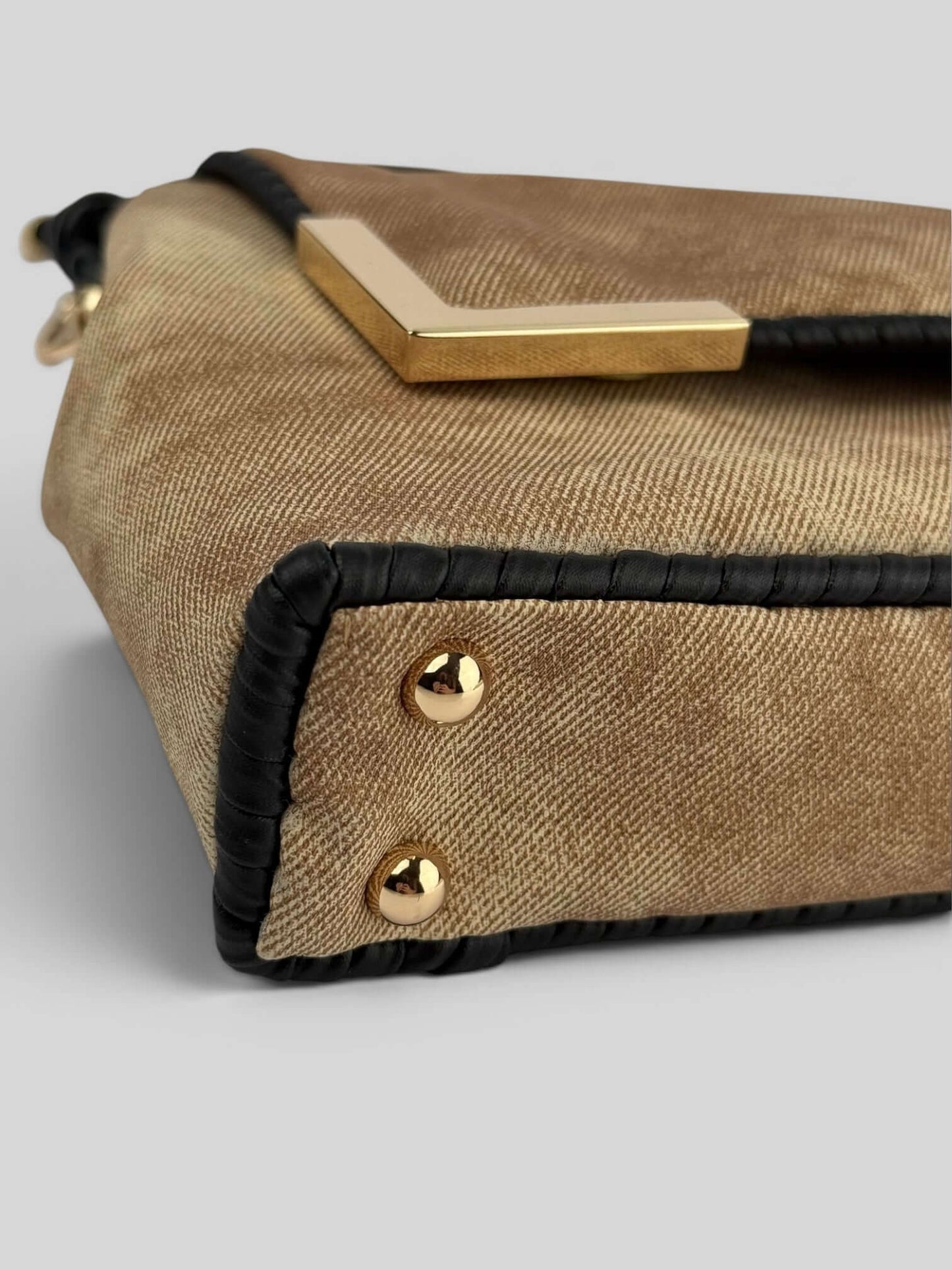 Bottom detail of Denim Beige bag with gold studs and black accents. Denim Beige is a Luxury Handmade Designer Bag by CATTLEYA.Y
