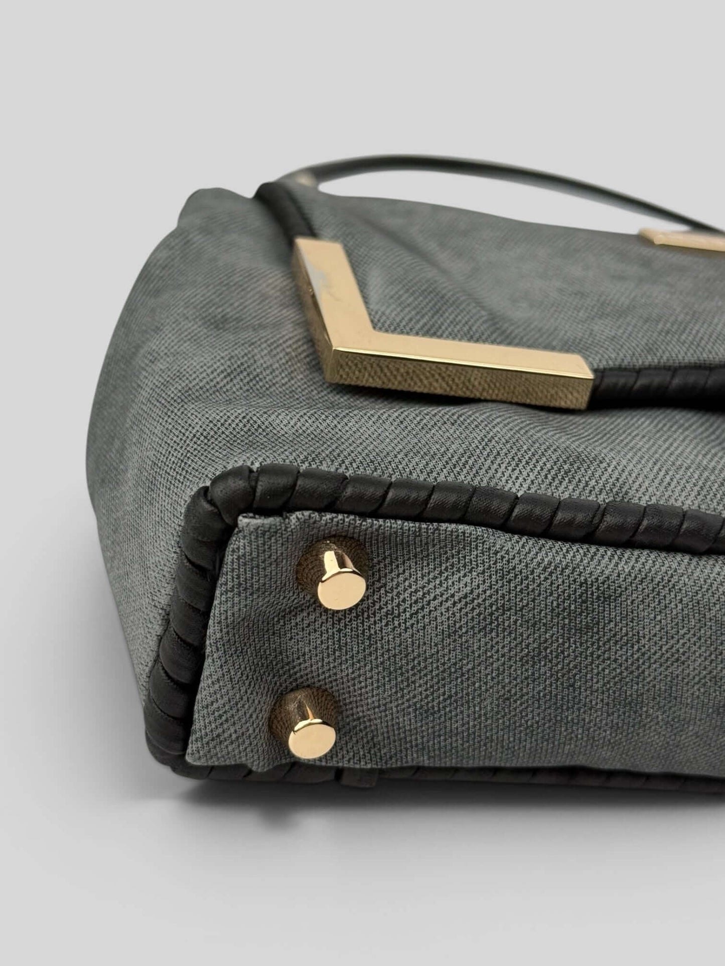 Bottom detail of Denim Graphite bag with gold studs and black accents. Denim Graphite is a Luxury Handmade Designer Bag by CATTLEYA.Y