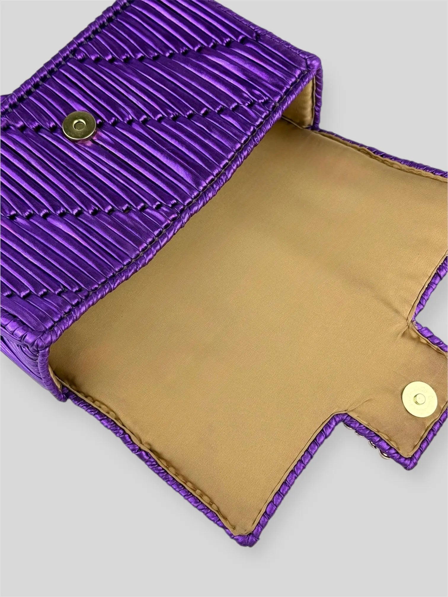 Destiny Amethyst is a luxury handmade designer bag by CATTLEYA.Y, inspired by the depth and brilliance of precious gemstones. The rich purple satin-finish yarn creates a luminous surface that captures light with regal intensity.
Golden satin lining inside Destiny Amethyst designer bag.