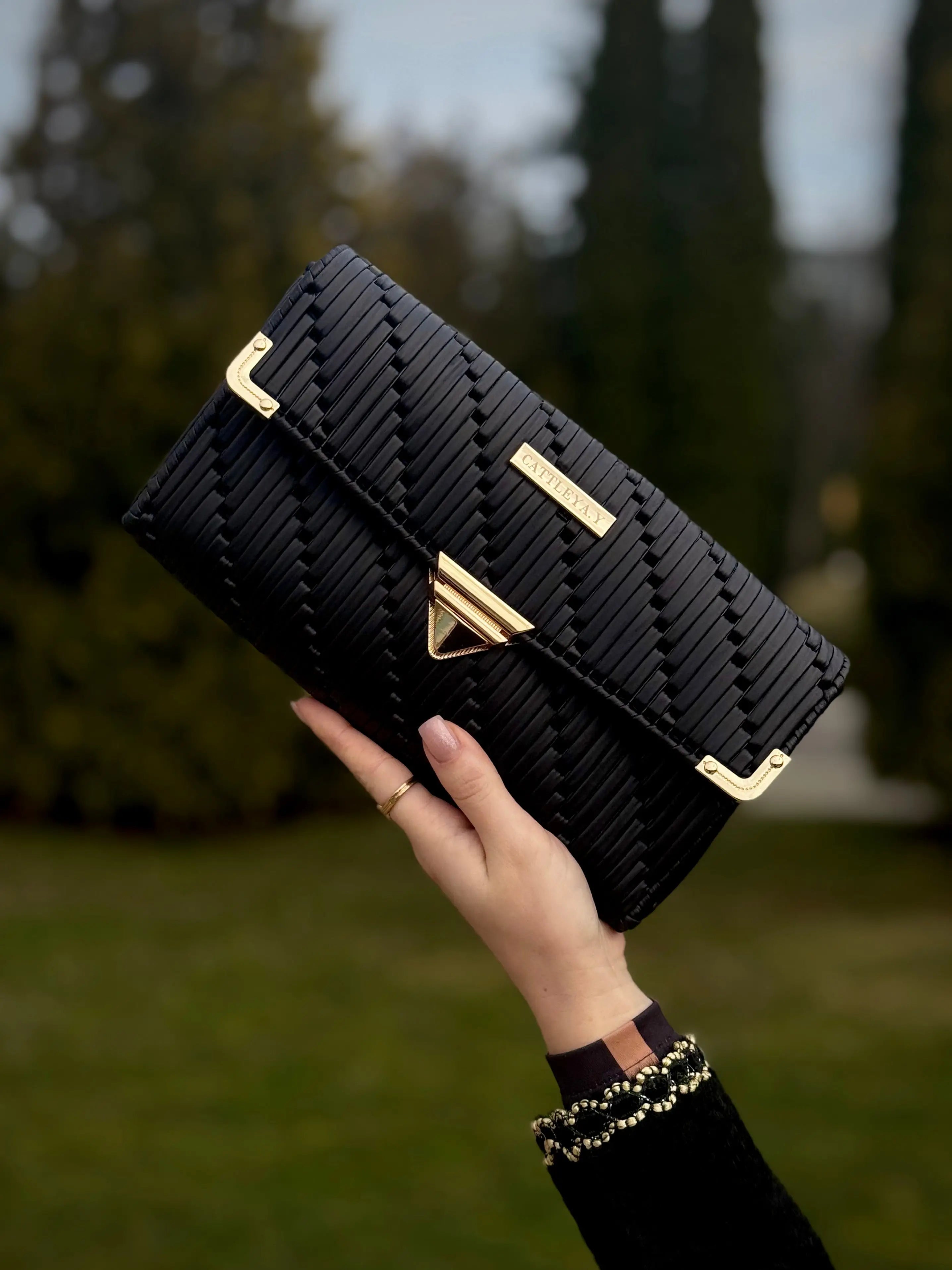 Tiffany is a black luxury handmade designer bag by CATTLEYA.Y front view with gold hardware