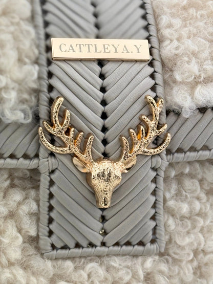 Vivian is a luxury handmade designer bag by CATTLEYA.Y, created for women who appreciate refined winter elegance. The combination of eco-leather yarn and soft bouclé texture creates depth, contrast and sophisticated character.
Gold-tone deer accent detail on Vivian designer bag.